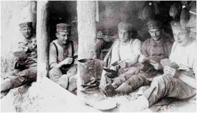 Relaxing WWI soldiers (identifiable as German by their cap cockades) demonstrate pants tucked into socks.