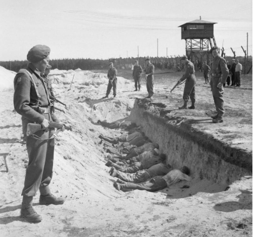  German SS guards at Bergen-Belsen, exhausted from their forced labour clearing the bodies of the dead, are allowed a brief rest by British soldiers lying face down.