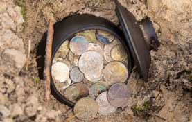 photograph of a pot of coins discovered buried in the ground